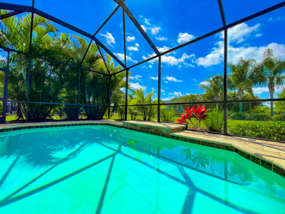 Screened pool lanai at a Tampa home with tropical landscaping